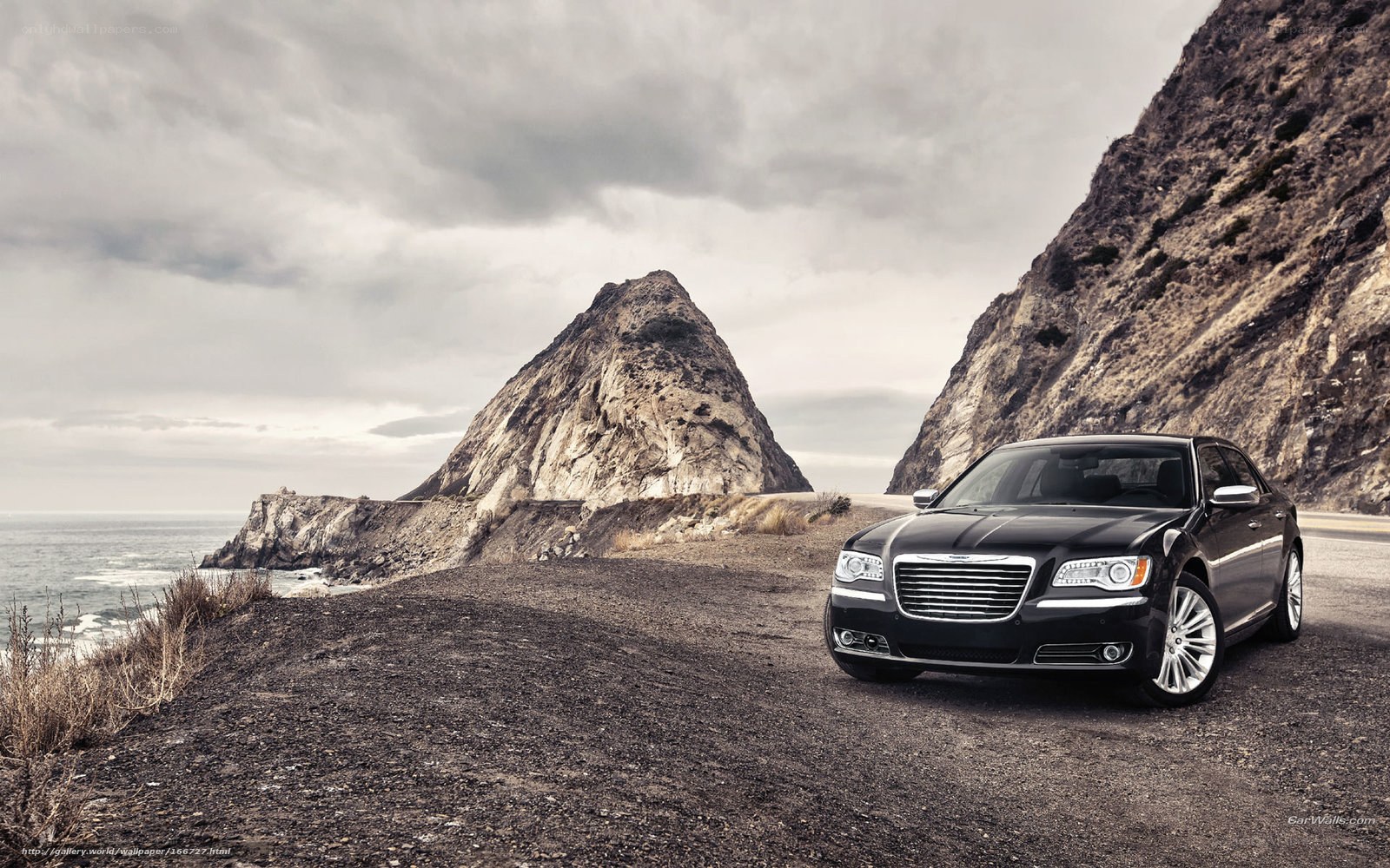Black sedan on coastal road