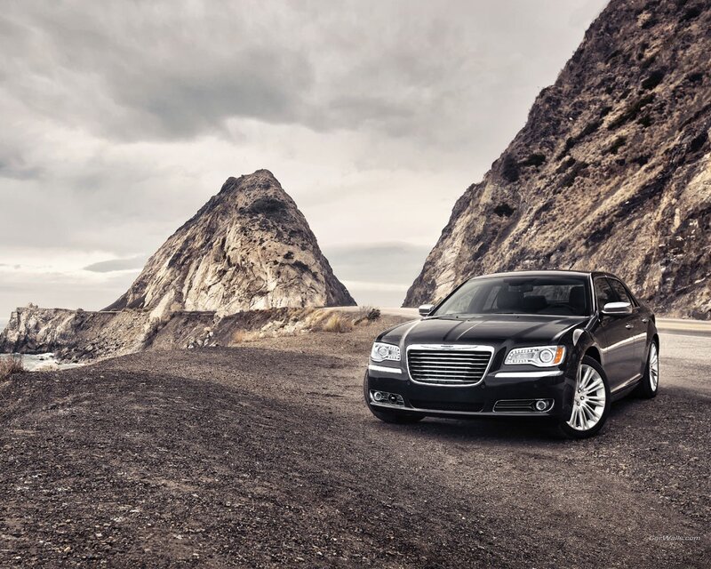 Black sedan on coastal road