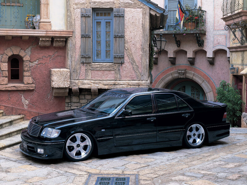Black sedan on cobblestone street