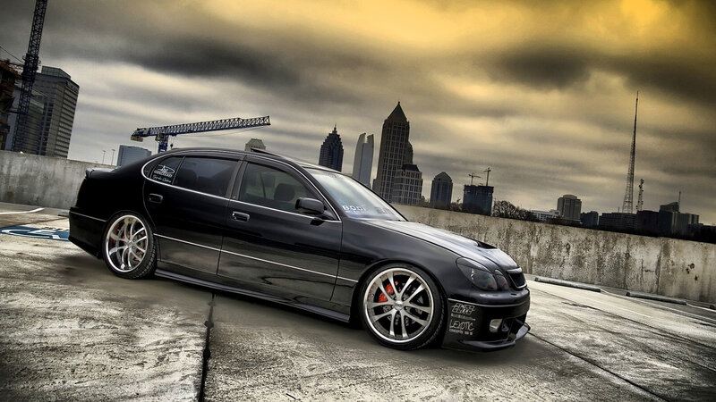 Black sedan on rooftop with city skyline