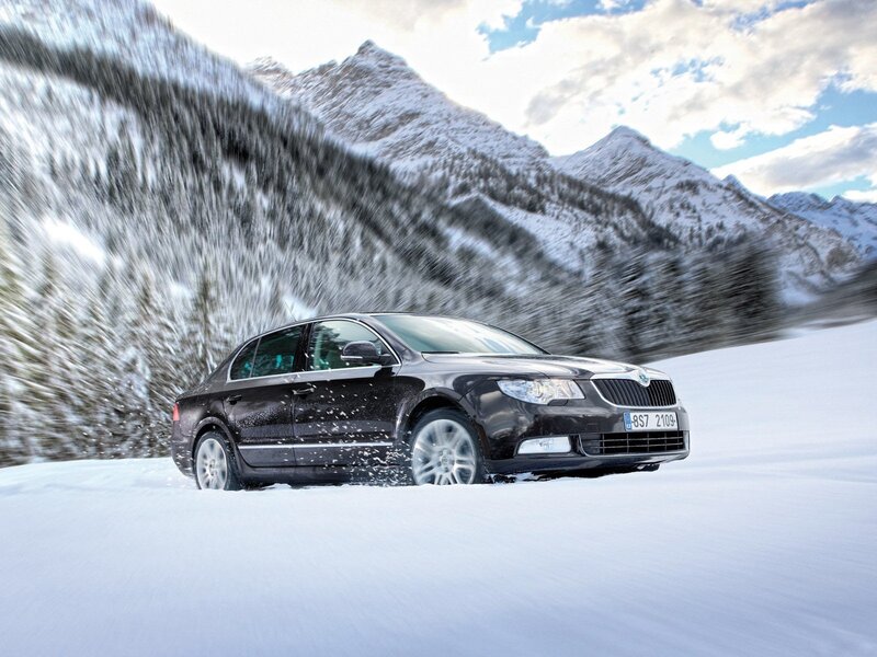 Black sedan on snowy mountain road