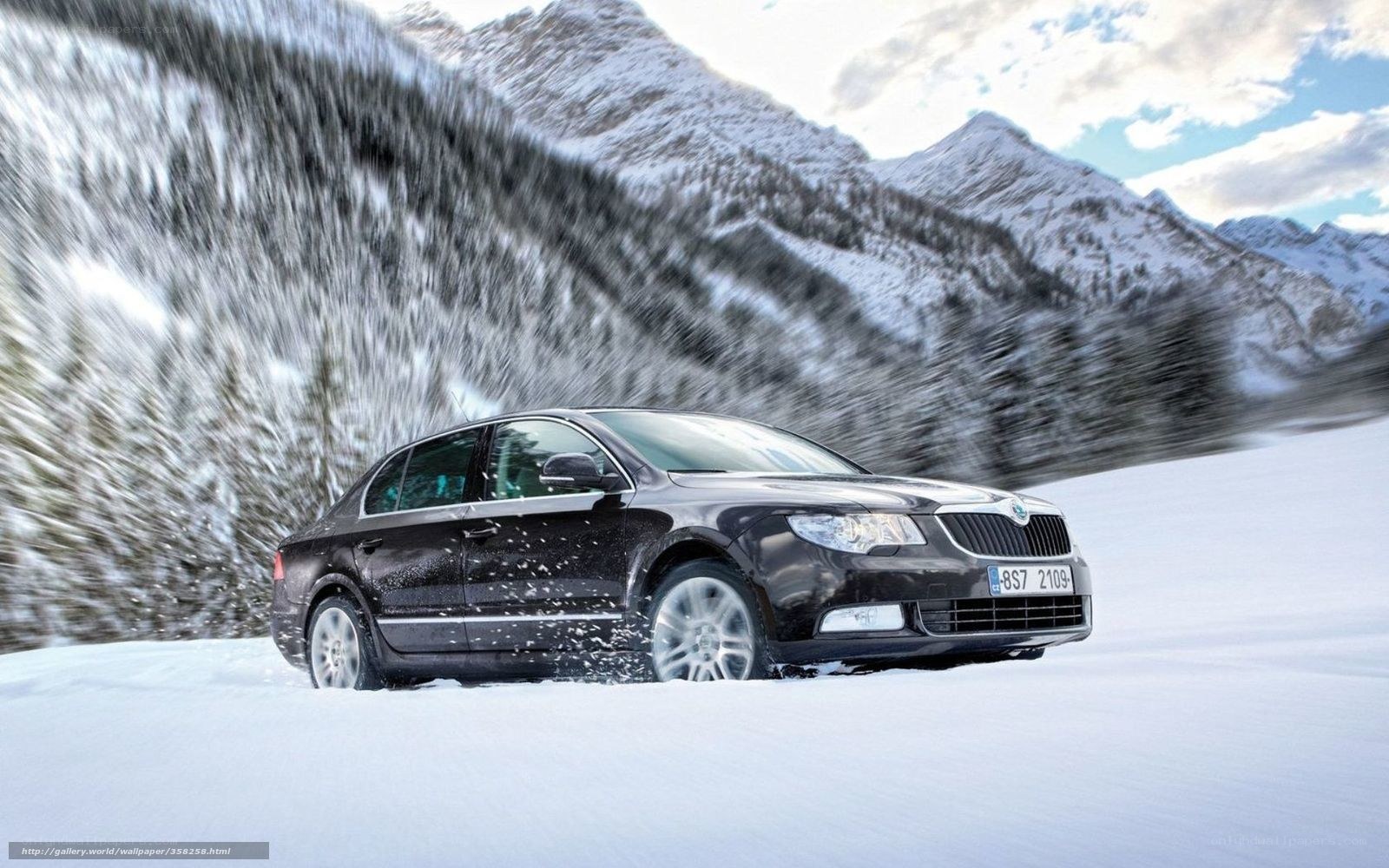 Black sedan on snowy mountain road