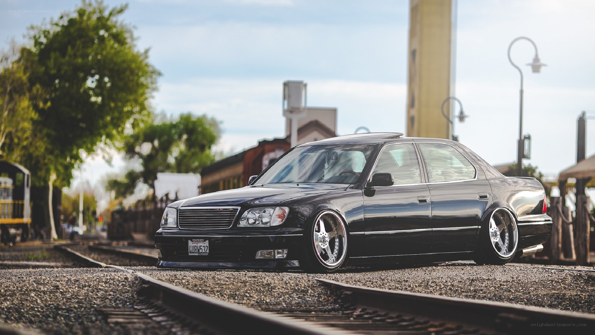black sedan on train tracks