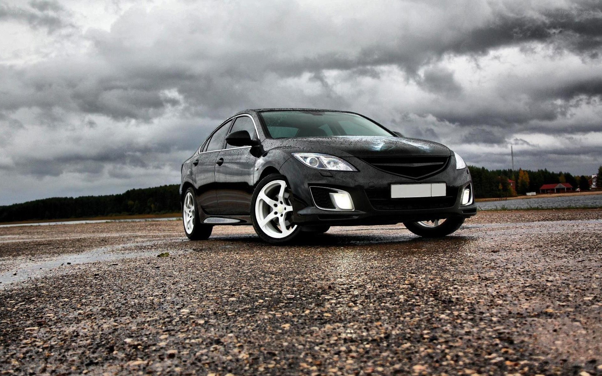 Black sedan on wet pavement