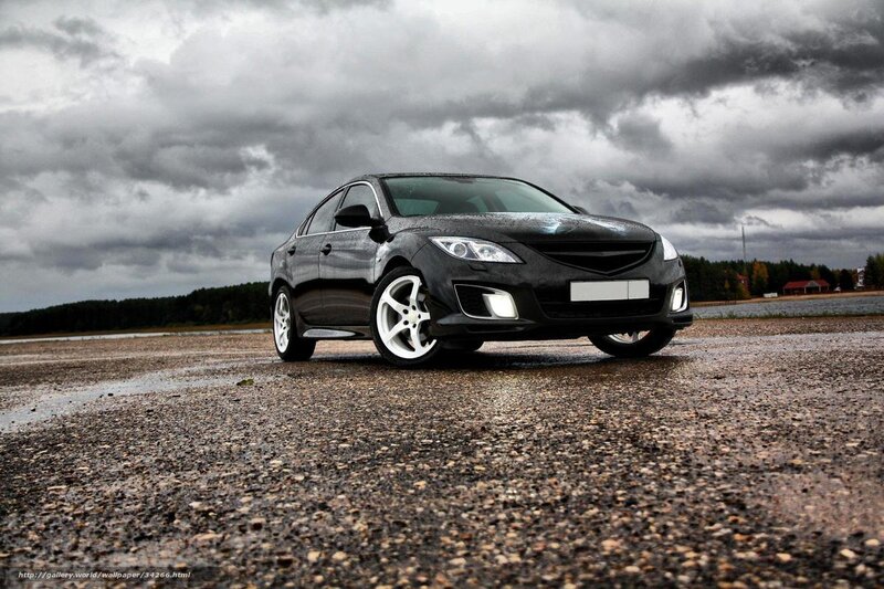 Black sedan on wet pavement