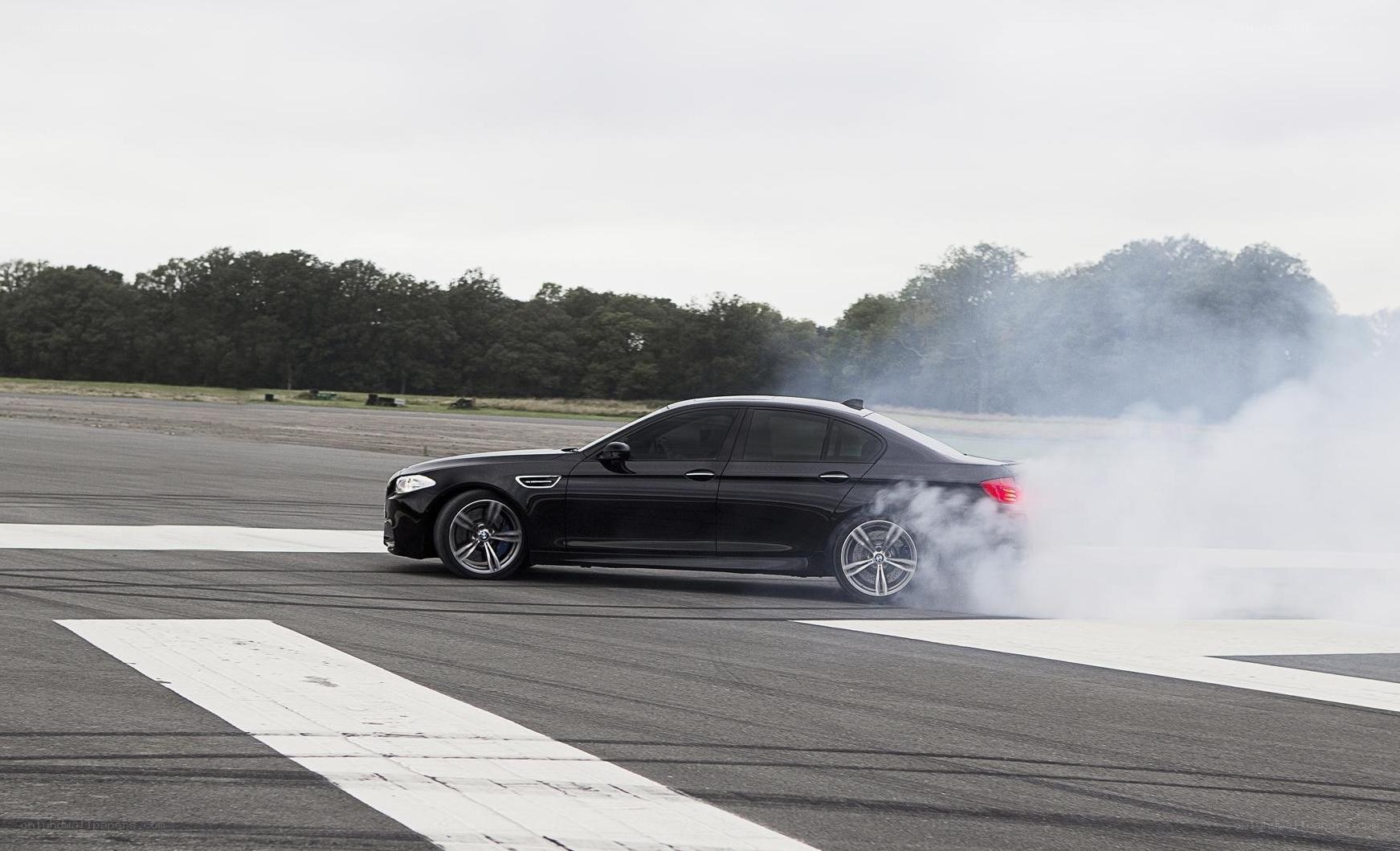 Black sedan performing burnout