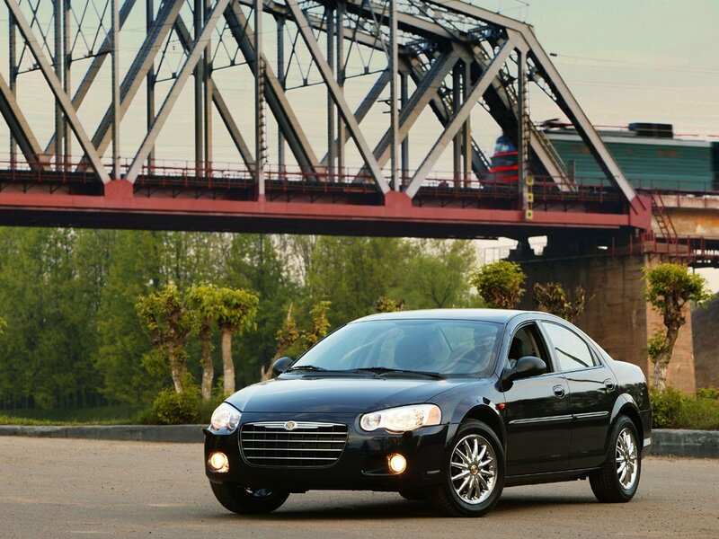 Black sedan under a bridge