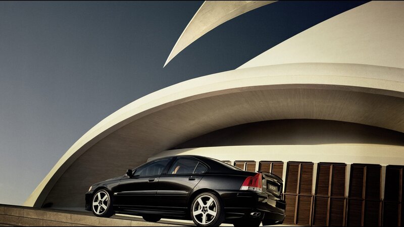 Black sedan under modern architecture