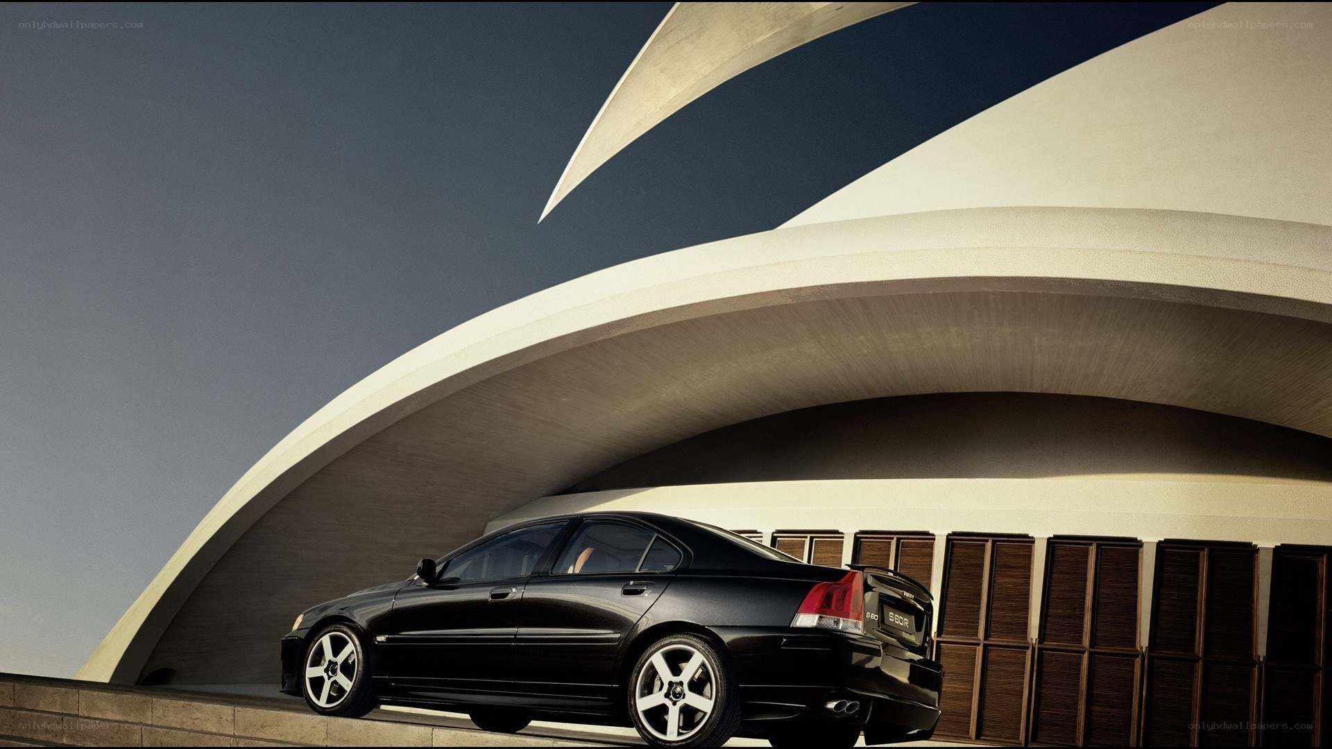 Black sedan under modern architecture