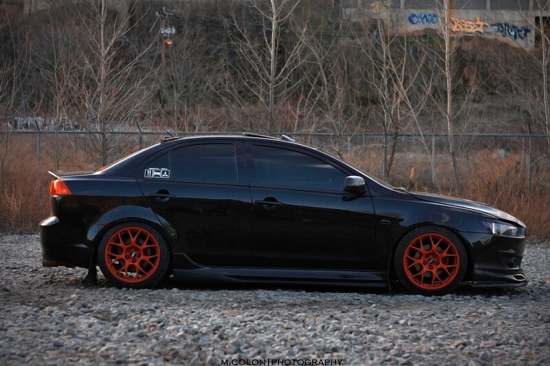black sedan with orange wheels