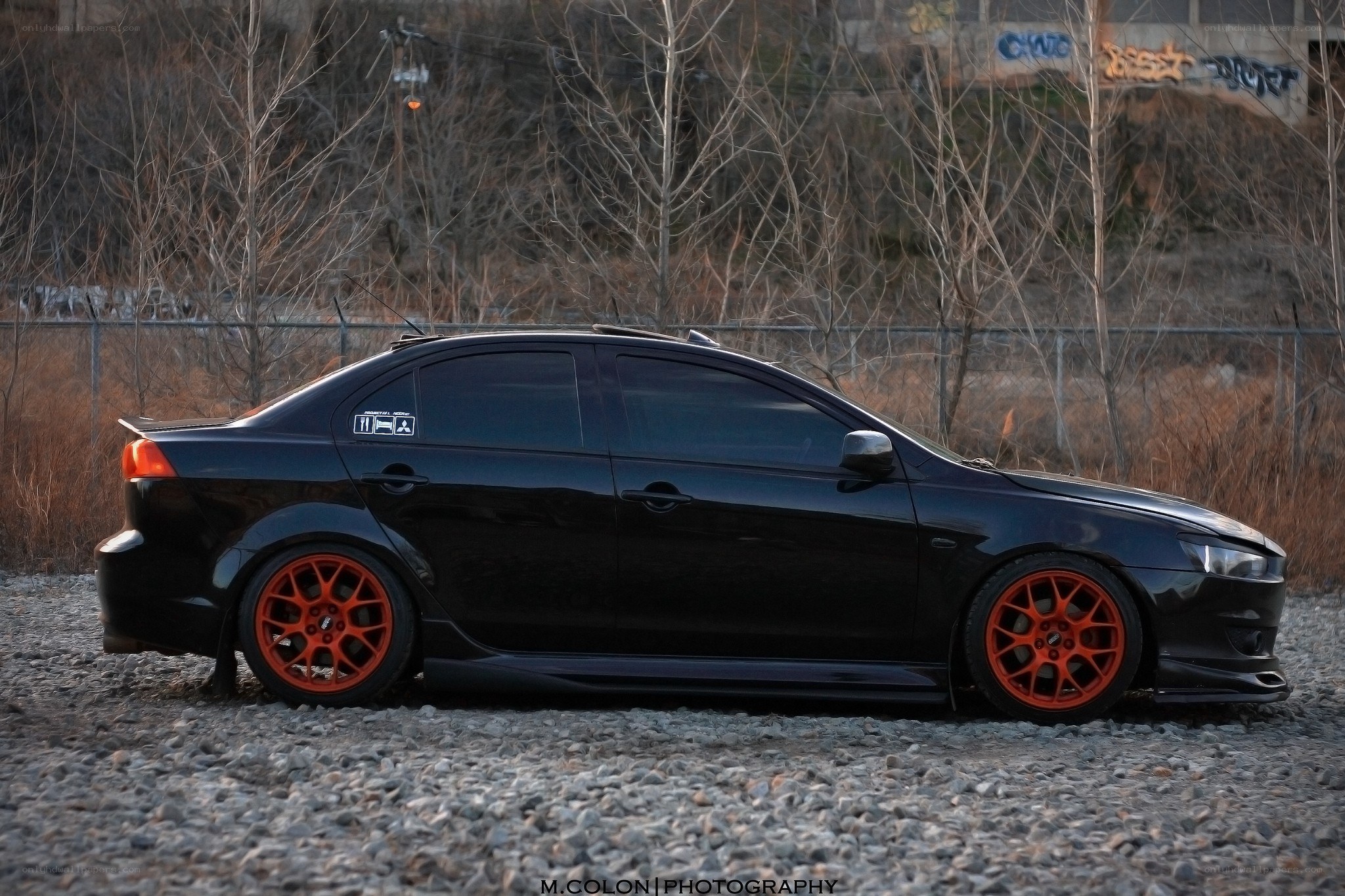 black sedan with orange wheels