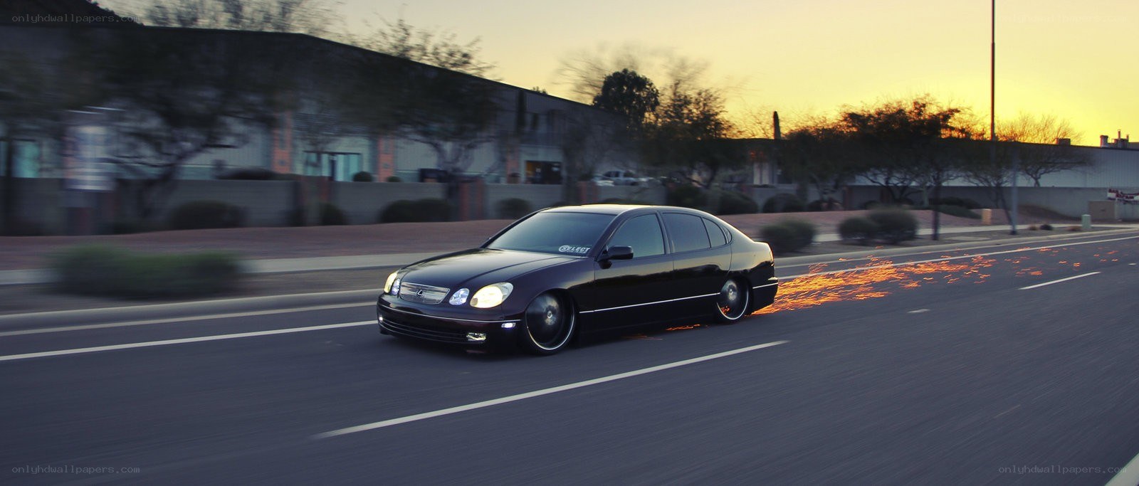 Black sedan with sparks at sunset