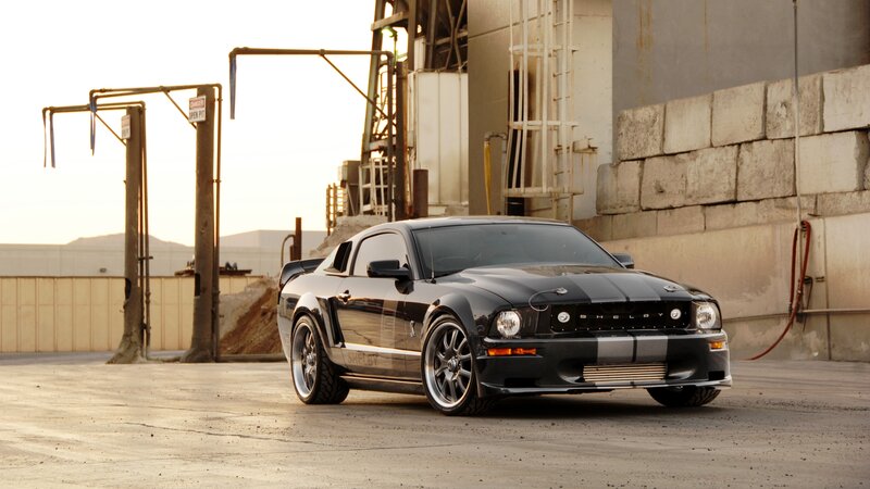 Black Shelby Mustang in industrial setting
