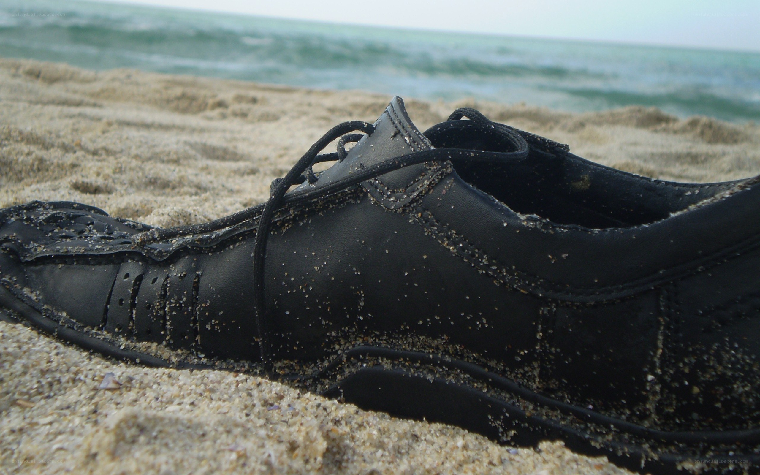 black shoe on sandy beach