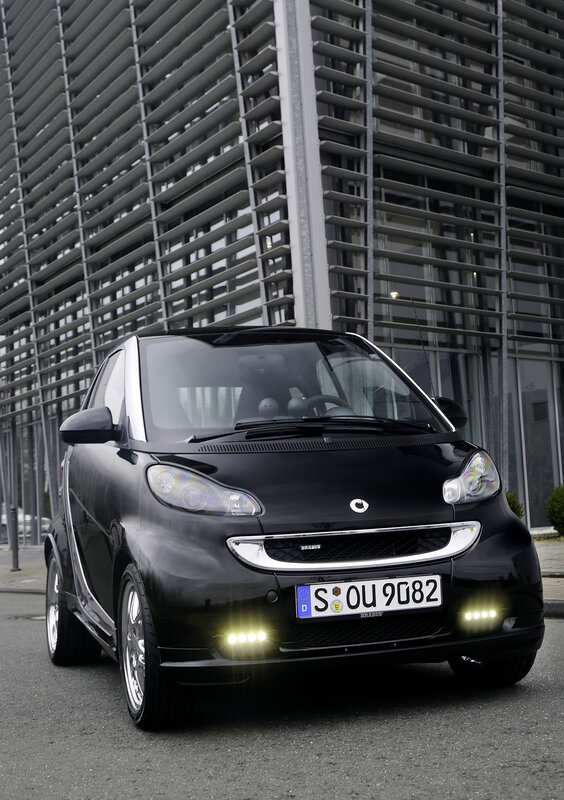Black smart car in front of building