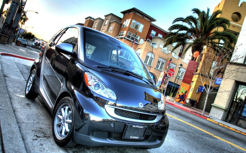 Black smart car on city street