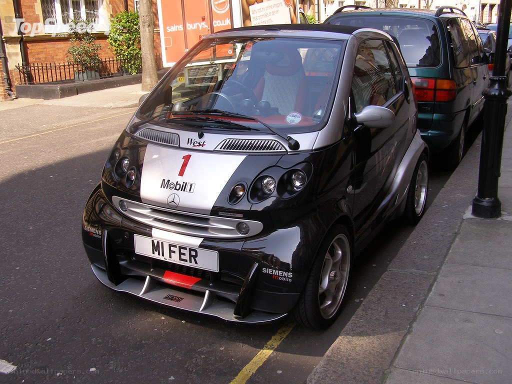 Black smart car with racing decals