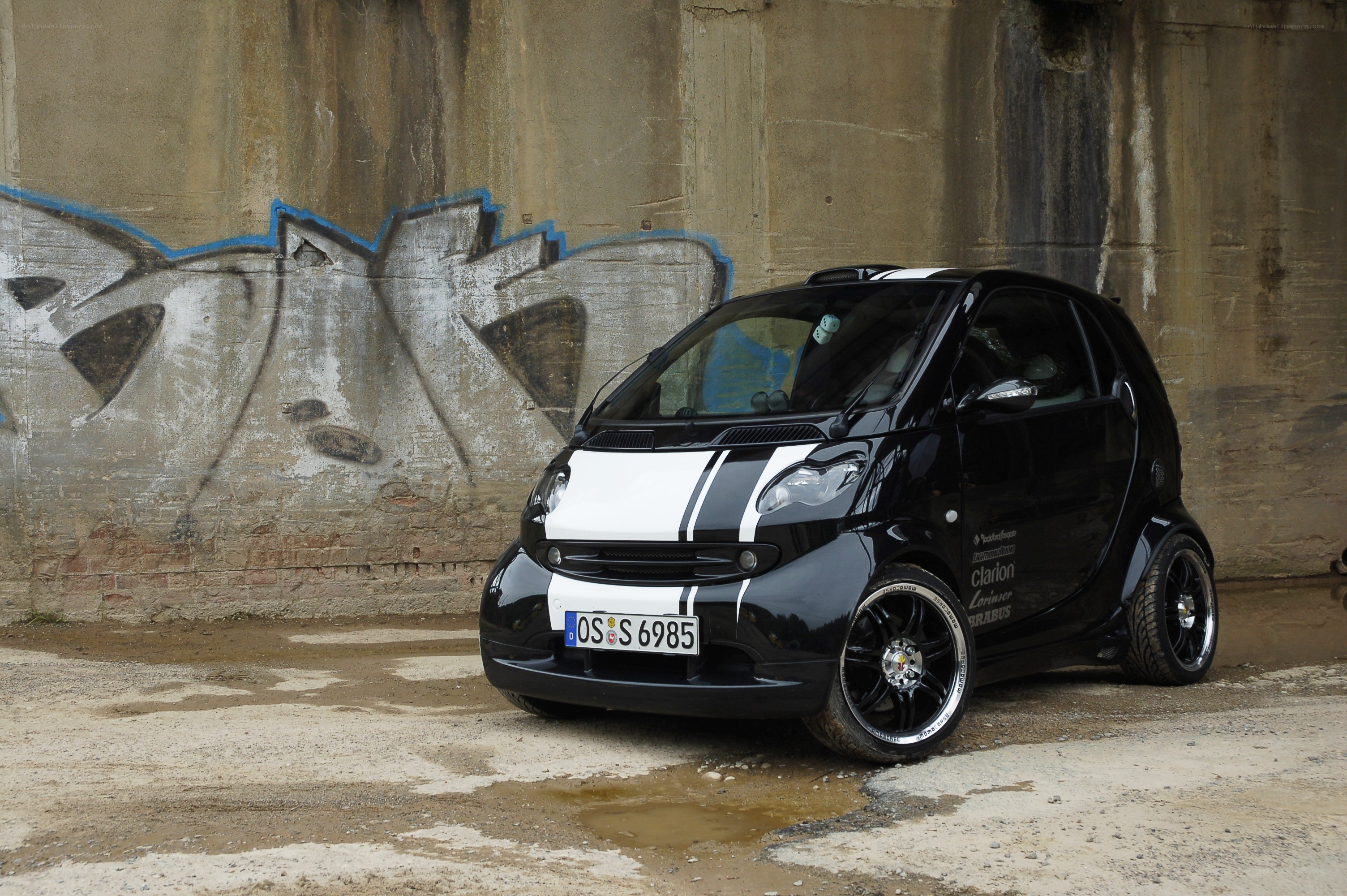 Black smart car with racing stripes