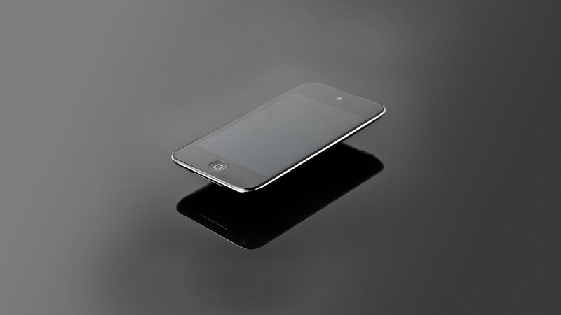black smartphone on reflective surface
