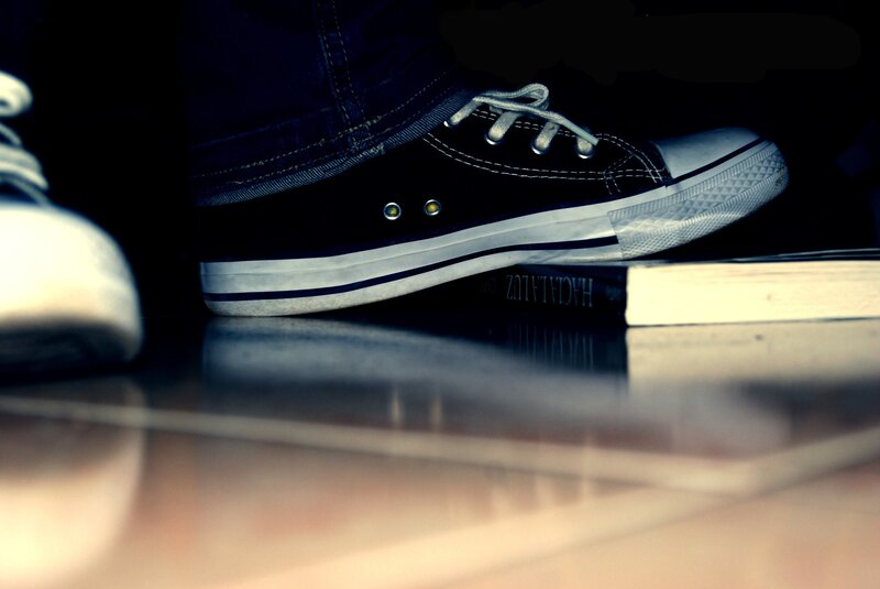 Black Sneaker on Book — Dramatic