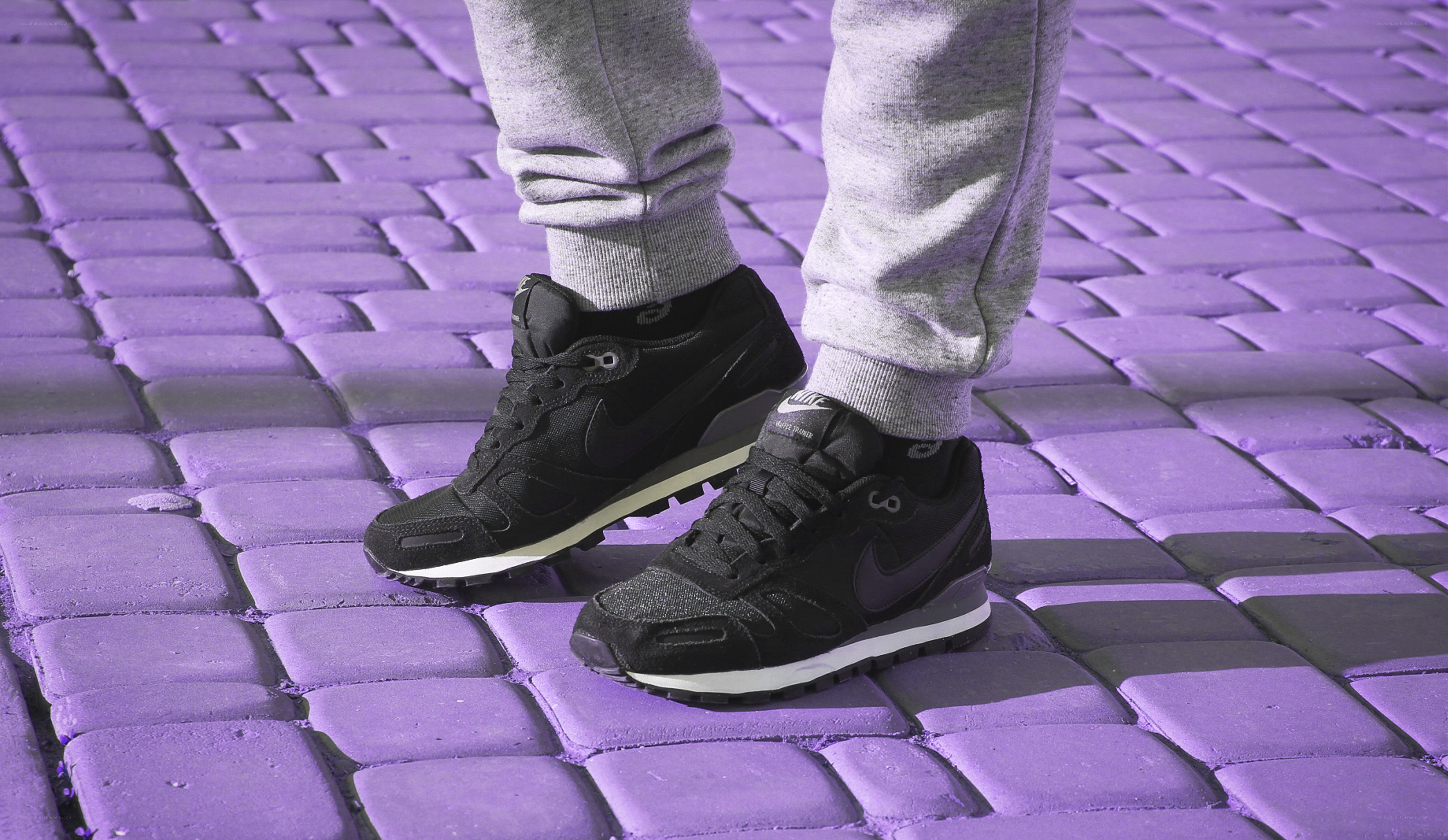 black sneakers on purple pavement