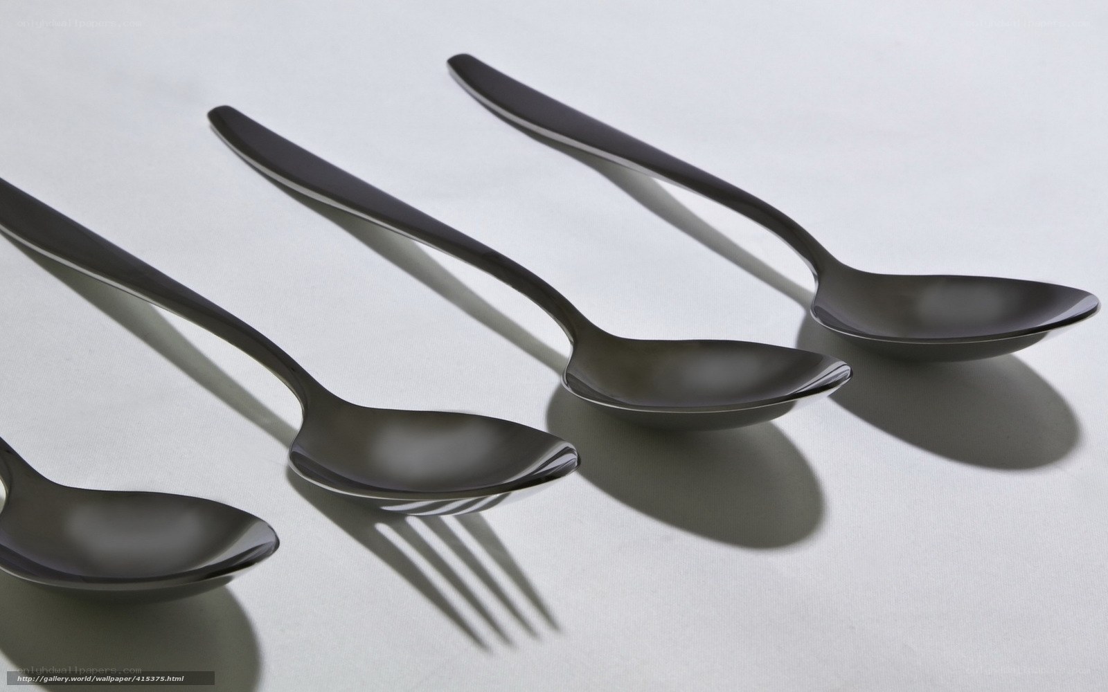 Black spoons on white surface