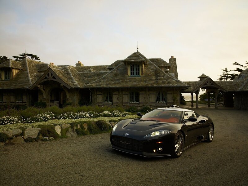 Black sports car at a stone house