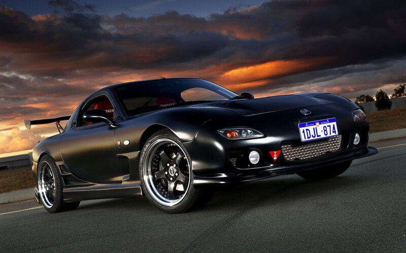 Black sports car at sunset