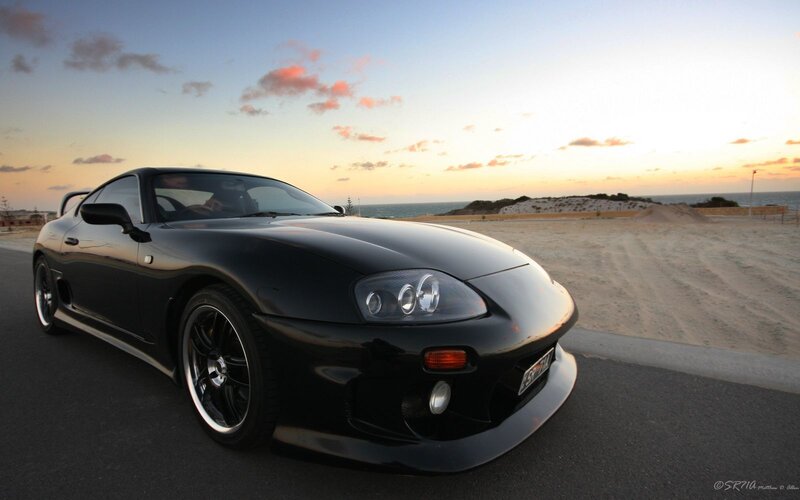 Black sports car at sunset