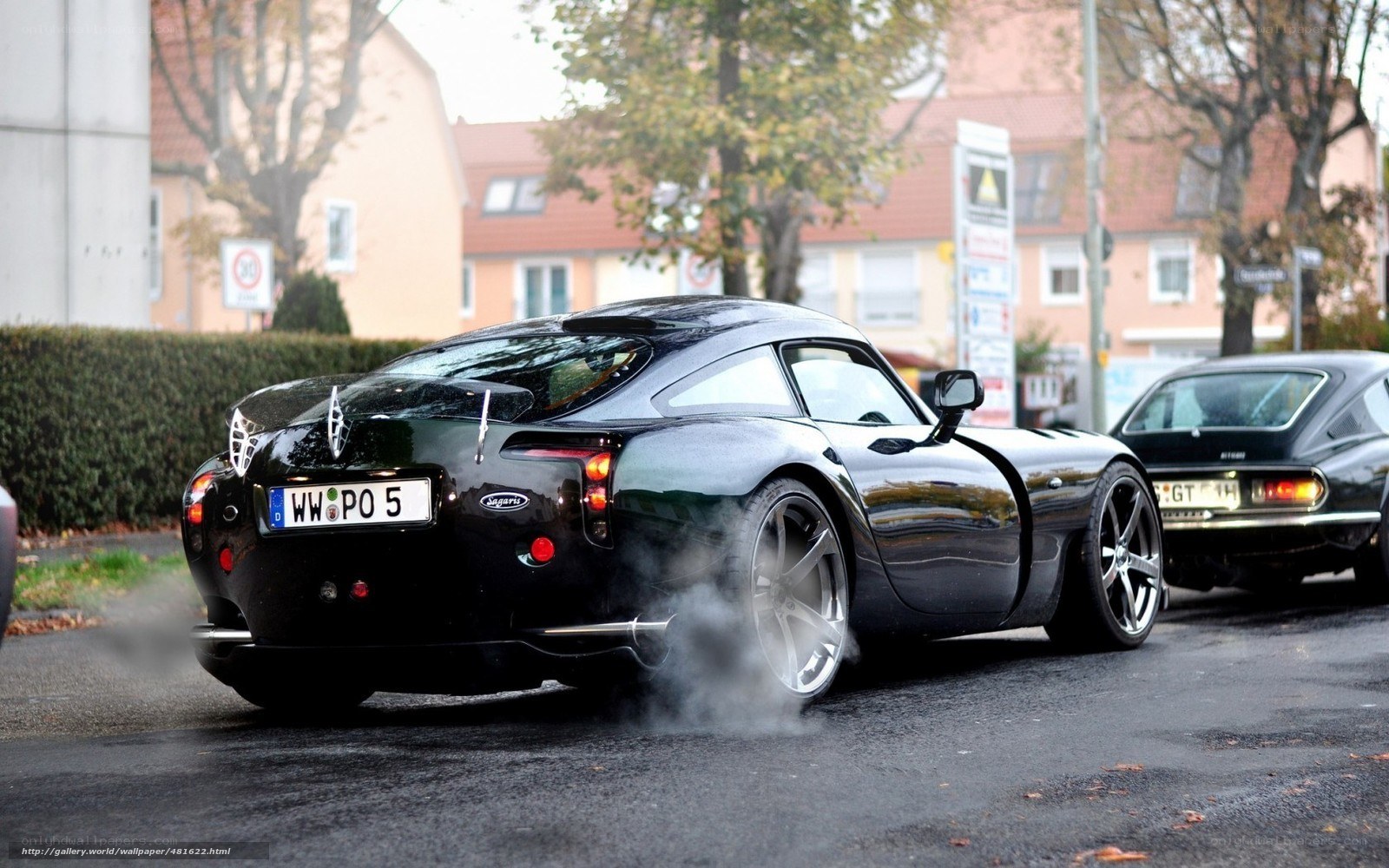black sports car burning rubber