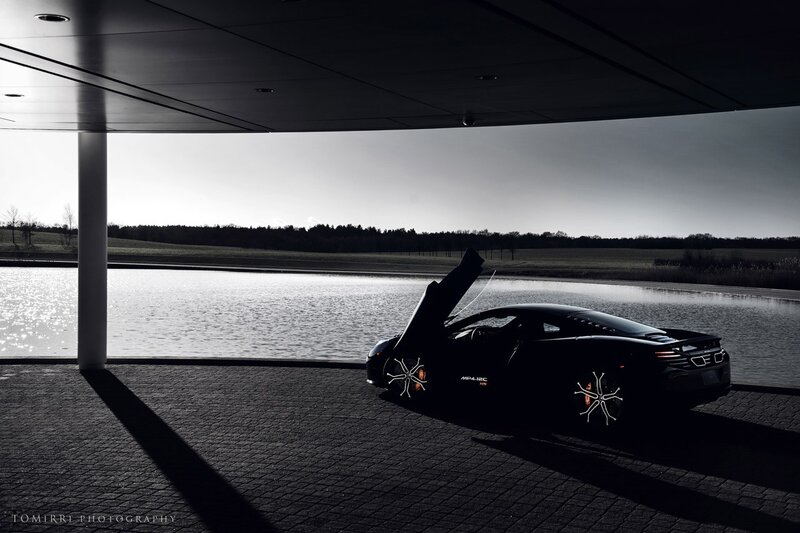 Black sports car by a lake