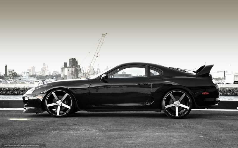 Black sports car by the harbor