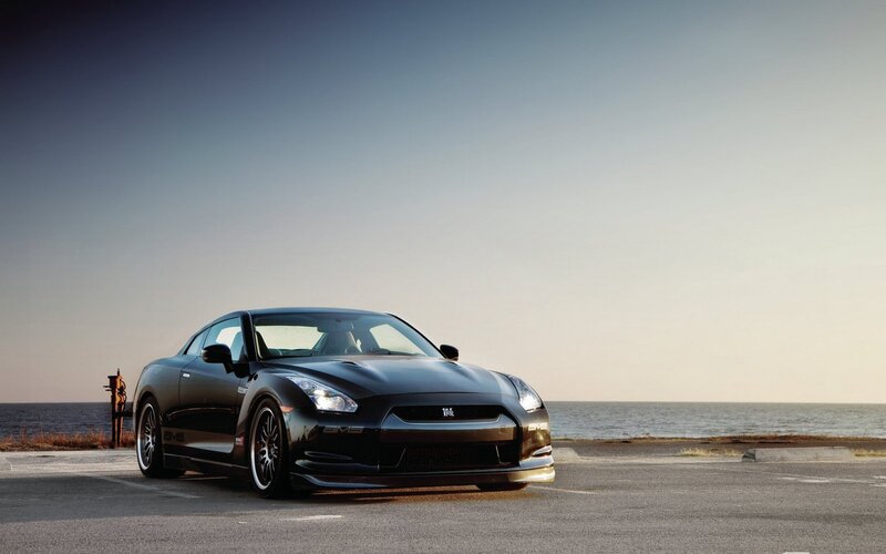 Black sports car by the sea
