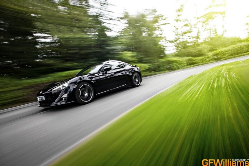 Black Sports Car — Dynamic, Afternoon, Photograph, Road, Trees, Grass, Green, Gray