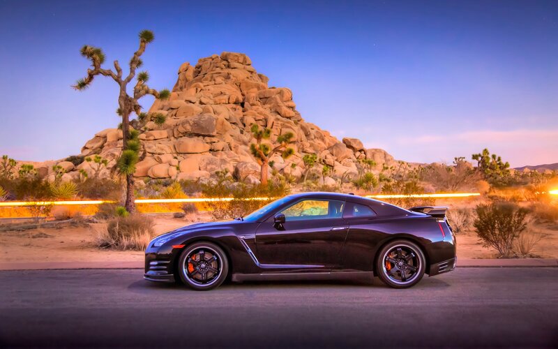 Black sports car in desert landscape