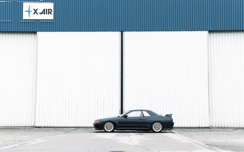 Black sports car in front of garage