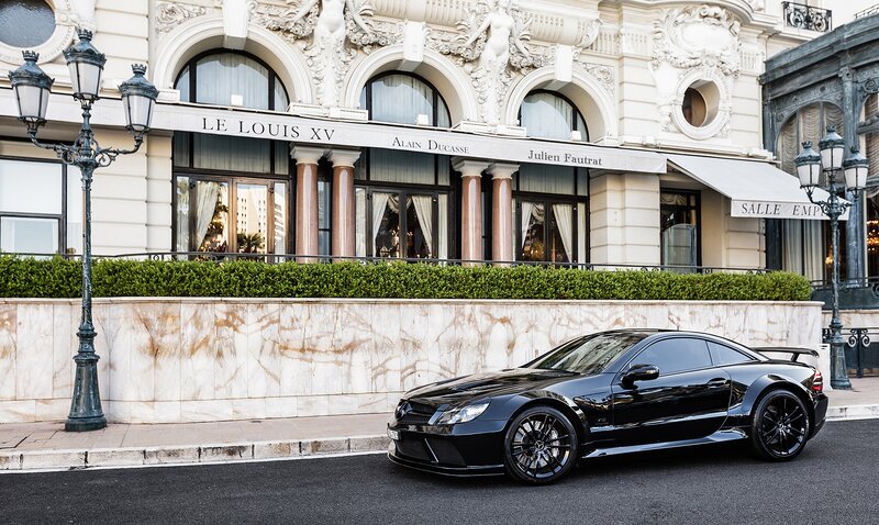 Black sports car in front of luxury hotel