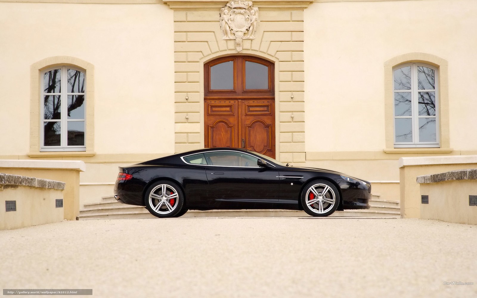 Black sports car in front of mansion
