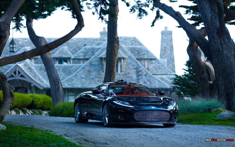 Black sports car in front of stone house