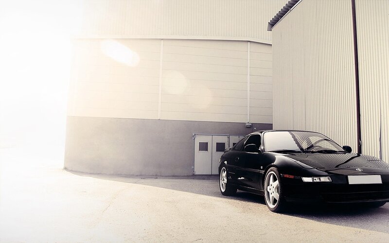 Black sports car in industrial setting