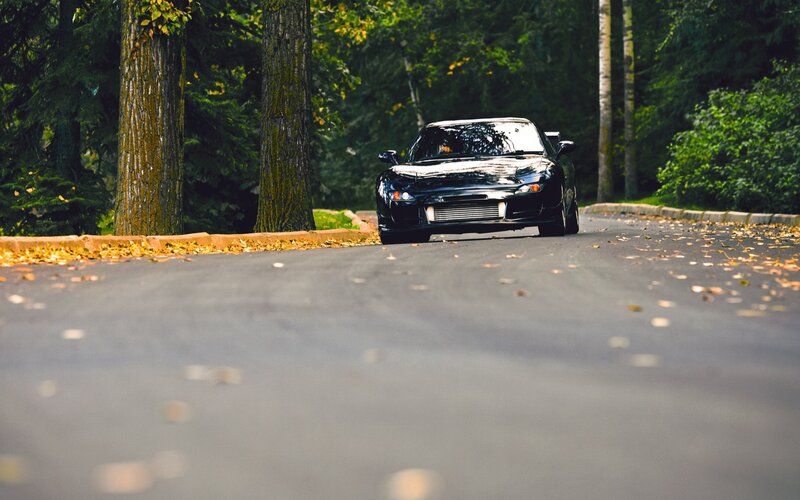 Black sports car on a forest road