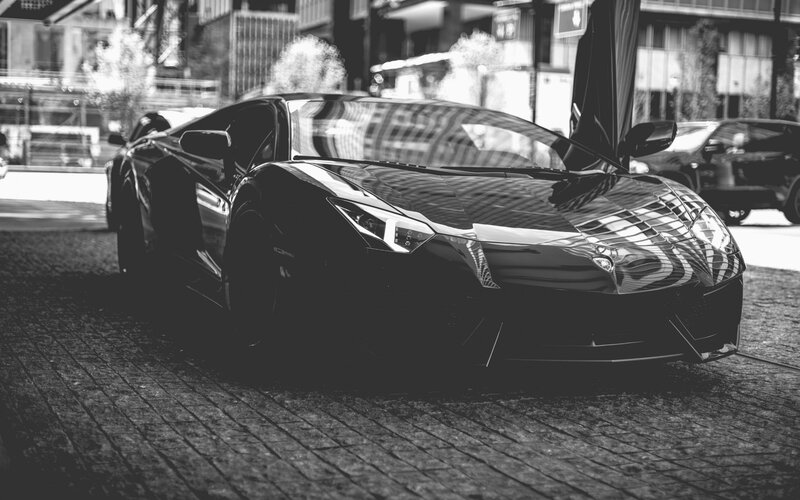 Black sports car on cobblestone