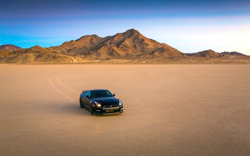 Black sports car on desert plain
