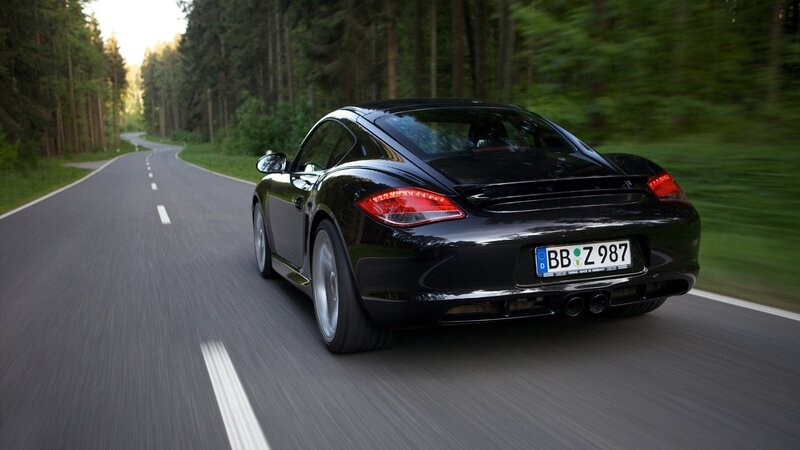 black sports car on forest road
