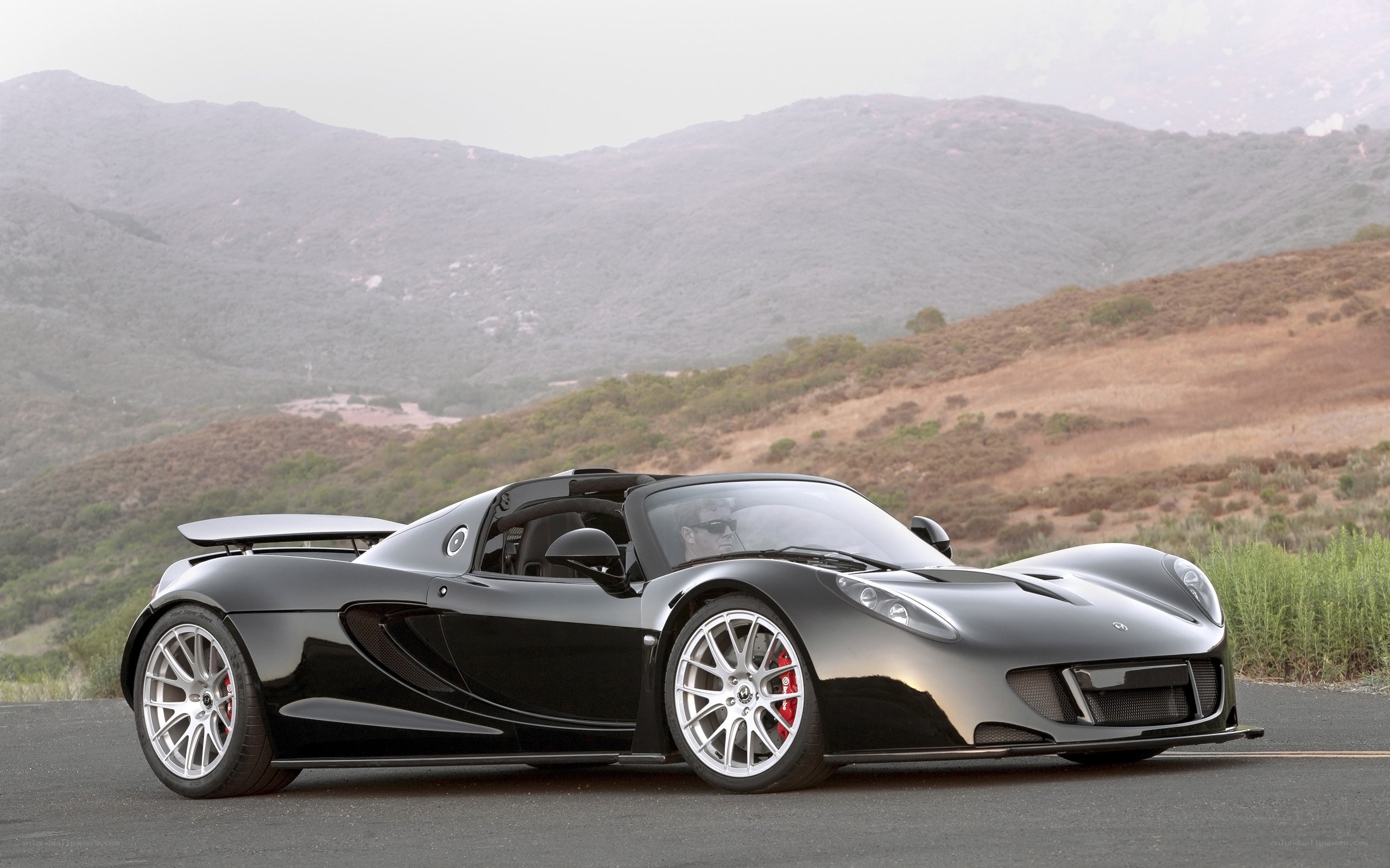 Black sports car on mountain road