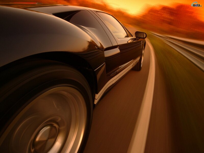 Black sports car on road at sunset