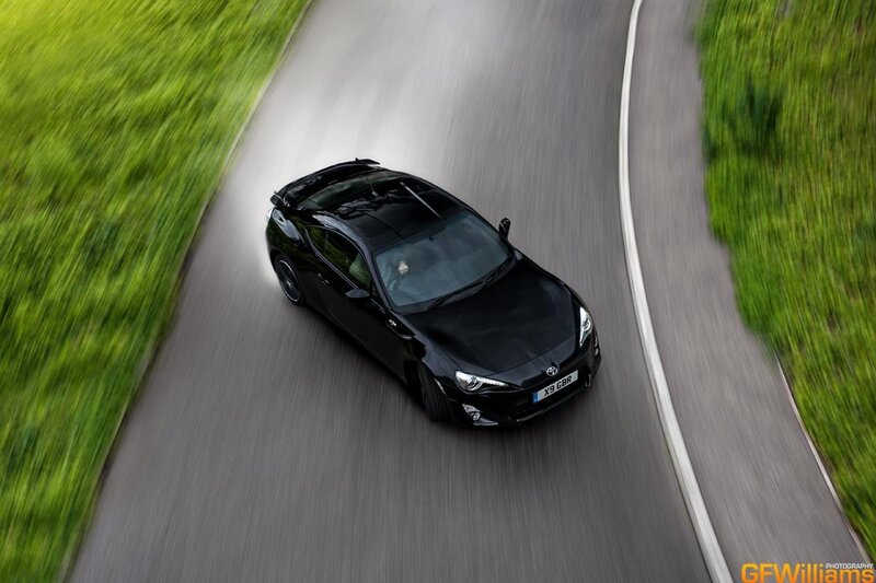Black Sports Car on Road — Dynamic, Afternoon, Photograph, Grass