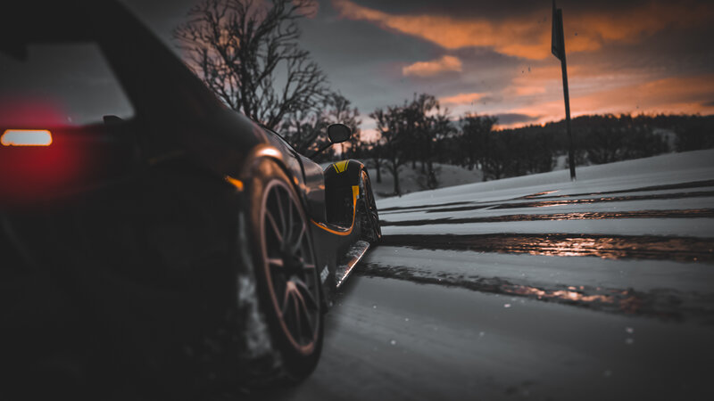 Black Sports Car on Snow — Dramatic, Sunset