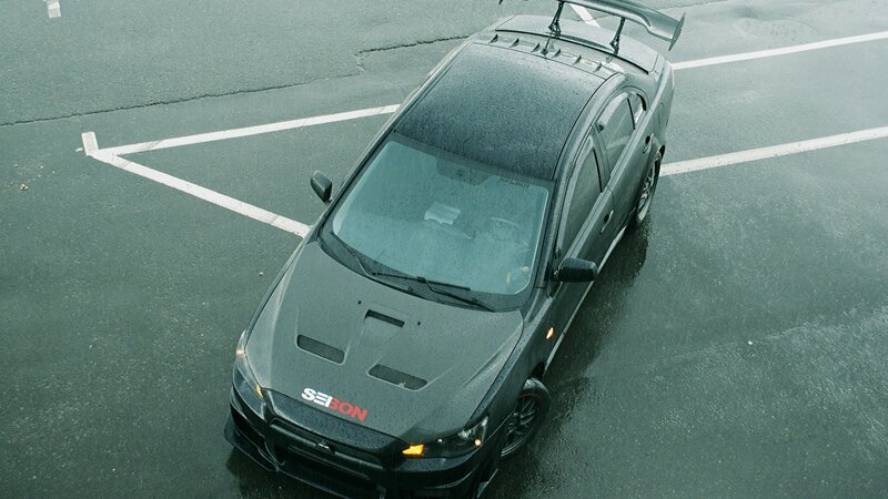 black sports car on wet pavement