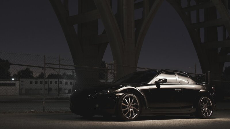 Black sports car under a bridge